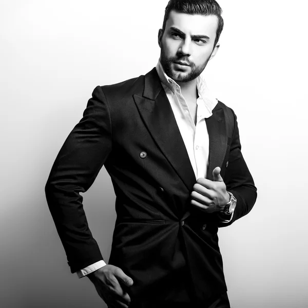 Elegante joven guapo en traje clásico. Retrato de moda estudio blanco y negro . — Foto de Stock