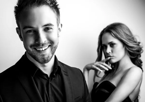 Портрет молодої привабливої пари позують студії, одягнені в чорний модний одяг. Чорно-біле фото . — стокове фото