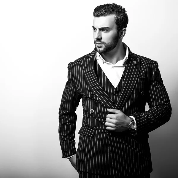 Eleganter junger gutaussehender Mann in klassischem Kostüm. Schwarz-weißes Modeporträt im Studio. — Stockfoto