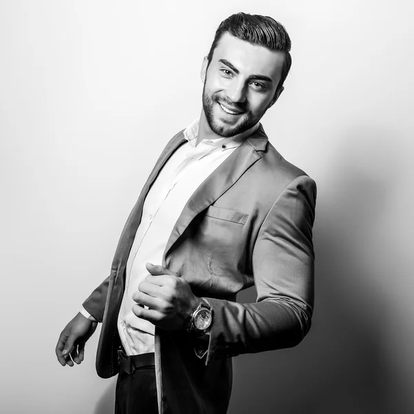 Elegant young handsome man in classic costume. Black-white studio fashion portrait.