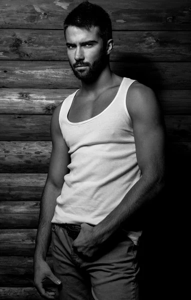 Retrato blanco y negro de joven hermoso hombre de moda contra la pared de madera . — Foto de Stock