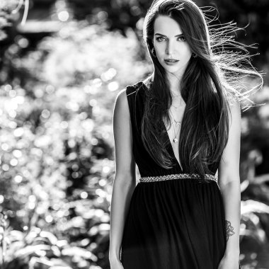 Siyah-beyaz açık havada dikey moda yaz bahçede poz içinde güzel genç kadın.