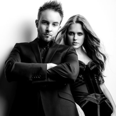 Portre studio poz genç çekici çift siyah moda kıyafetler giymiş. Siyah-beyaz fotoğraf.