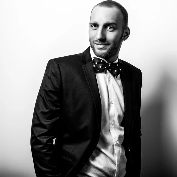 Elegante hombre guapo con estilo. Retrato de moda estudio blanco y negro . — Foto de Stock