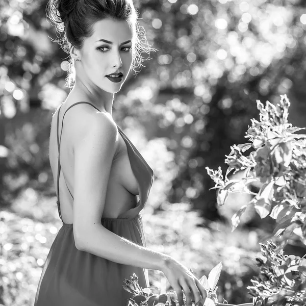 Kint gyönyörű fiatal barna lány luxus portréja ruha, nyári kert pózol. Fekete-fehér fénykép. — Stock Fotó