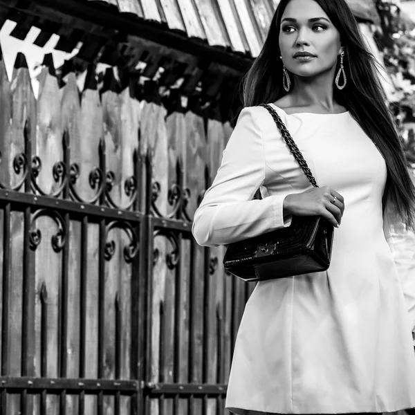 Portrait extérieur noir-blanc de belle jeune fille en robe blanche de luxe posant dans le jardin d'été . — Photo