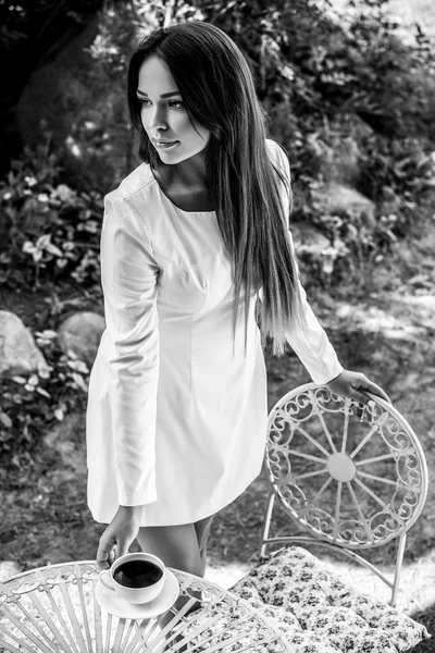 Чорно-білий на відкритому повітрі портрет красивої молодої дівчини в розкішній білій сукні позує в літньому саду . — стокове фото