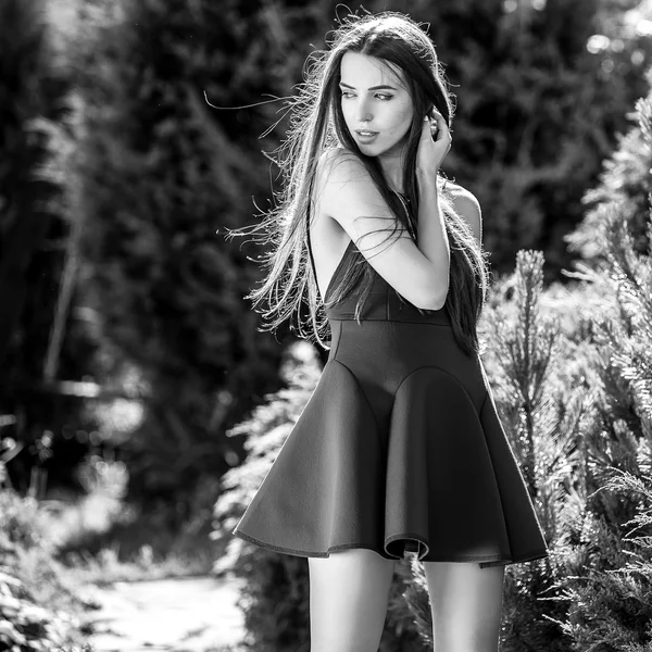 Black-white outdoors portrait of beautiful young woman in fashionable dress posing in summer garden. — Stock Photo, Image