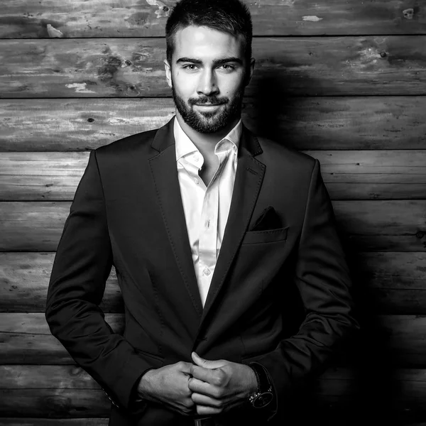 Retrato blanco y negro de joven hermoso hombre de moda contra la pared de madera . — Foto de Stock