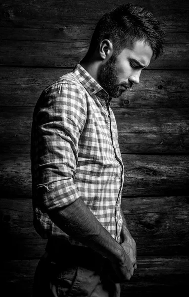 Black-white portrait of young beautiful fashionable man against wooden wall. — Stock Photo, Image