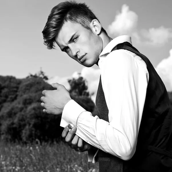 Schwarz-weißes Porträt eines schönen jungen Mannes im Freien. — Stockfoto