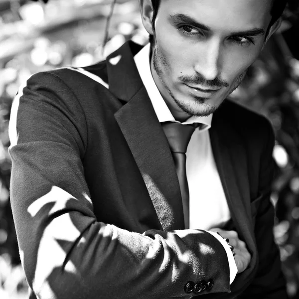 Közelkép portré fiatal komoly jóképű férfi klasszikus ruha szabadban. Fekete-fehér fénykép. — Stock Fotó