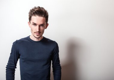 Şık koyu mavi t-shirt genç yakışıklı adam portresi stüdyo.