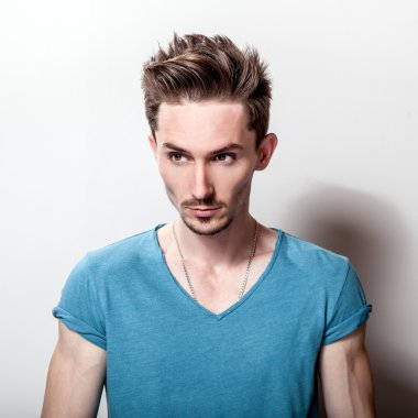 Stüdyo portre rahat turkuaz t-shirt genç yakışıklı adamın.