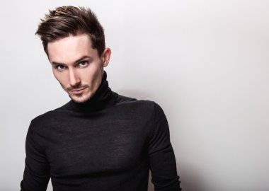 Çekici şık erkek siyah Golf ışık gri arka plan üzerinde poz.