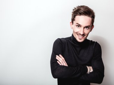 Çekici şık erkek siyah Golf ışık gri arka plan üzerinde poz.