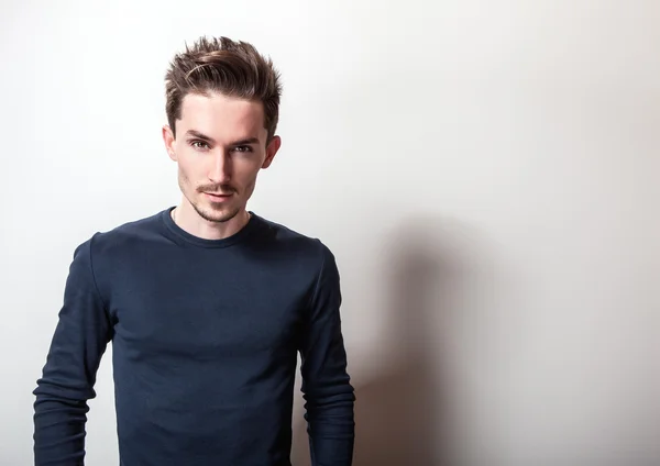 Portrait studio de jeune homme séduisant en t-shirt bleu foncé élégant . — Photo