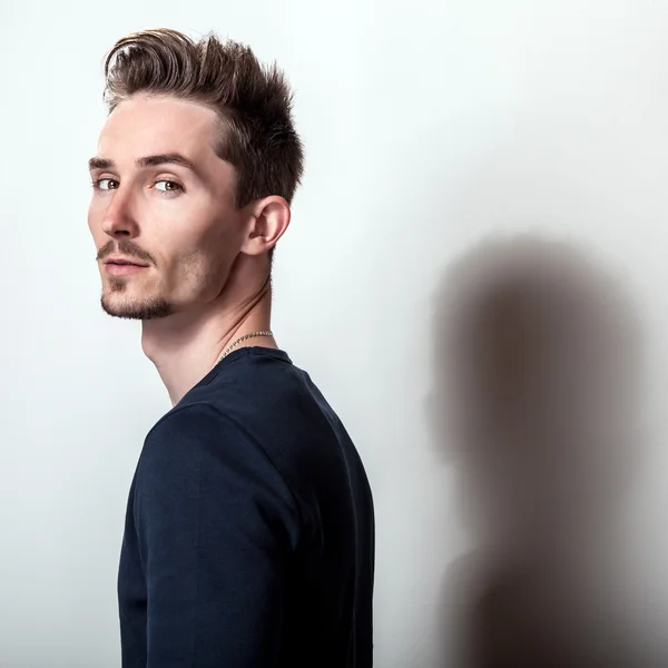 Studio portrait of young handsome man in stylish dark blue t-shirt. — Stock Photo, Image