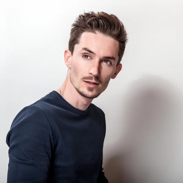 Estudio retrato de un joven guapo en elegante camiseta azul oscuro . — Foto de Stock