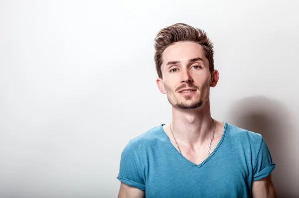 Studio portrait of young handsome man in casual turquoise t-shirt. — Stock Photo, Image