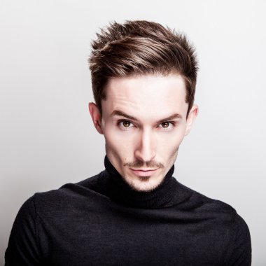 Çekici şık erkek siyah Golf ışık gri arka plan üzerinde poz.