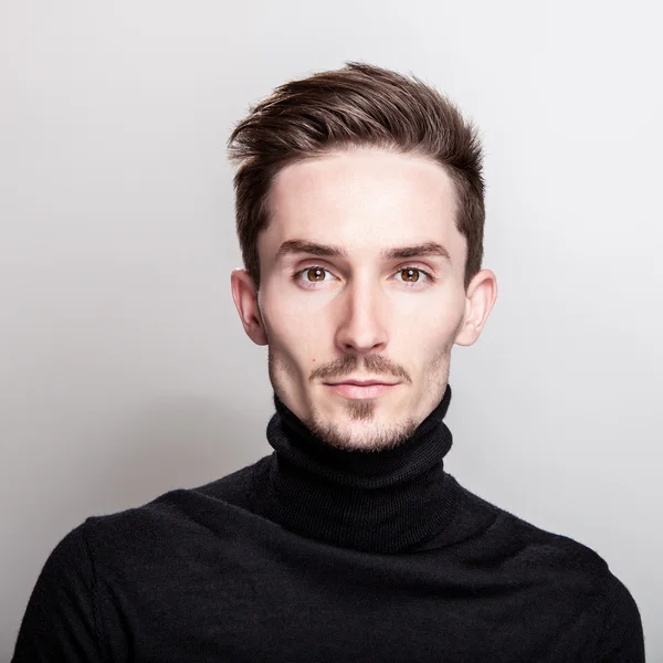 Çekici şık erkek siyah Golf ışık gri arka plan üzerinde poz.