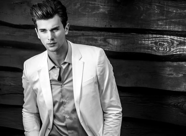 Portrait of young beautiful fashionable man against wooden wall — Stock Photo, Image