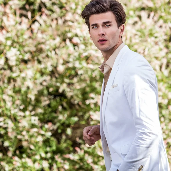 Elegante homem bonito em traje branco ao ar livre — Fotografia de Stock