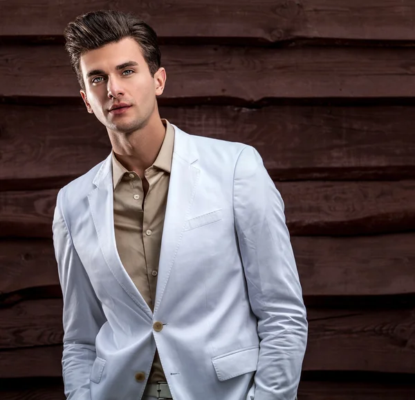 Portrait of young beautiful fashionable man against wooden wall — Stock Photo, Image