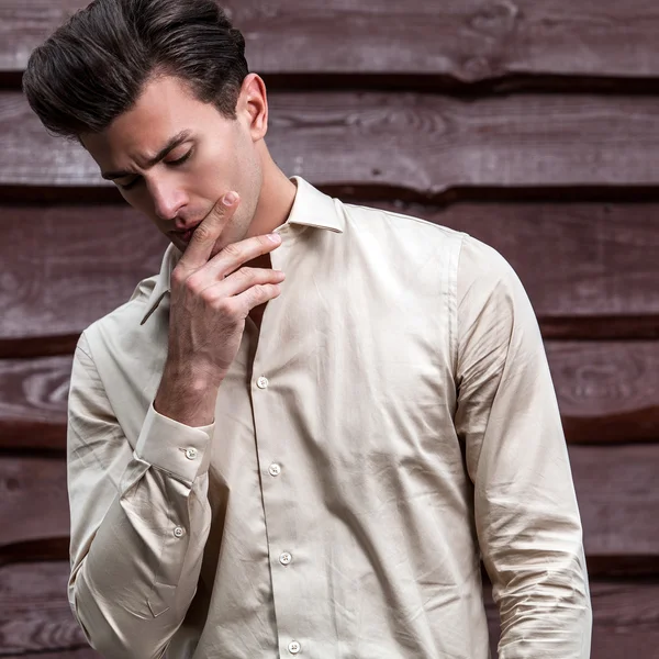 Retrato de joven hermoso hombre de moda contra la pared de madera —  Fotos de Stock