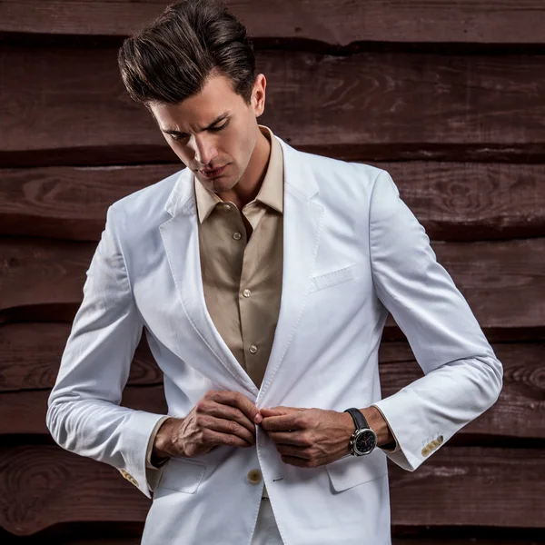 Portrait of young beautiful fashionable man against wooden wall — Stock Photo, Image