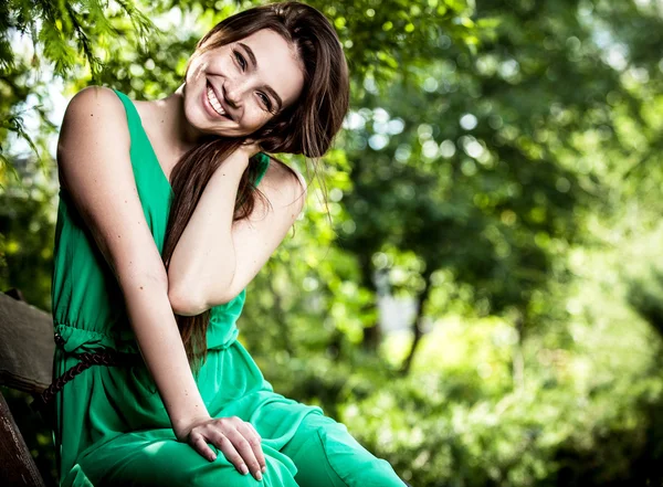 Outdoors portrait of beautiful emotional young woman in green dress — Stock Photo, Image