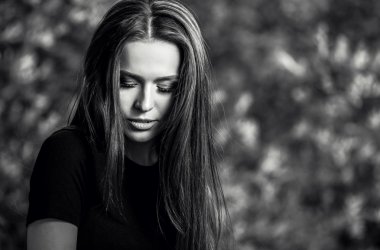 Açık havada siyah-beyaz güzel genç uzun saçlı esmer kadın portresi