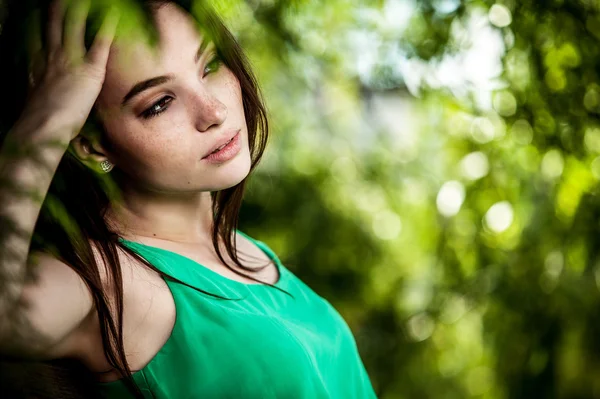 Openlucht portret van mooie emotionele jonge vrouw in groene jurk — Stockfoto