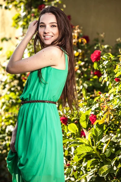На открытом воздухе портрет красивой эмоциональной молодой женщины в зеленом платье — стоковое фото