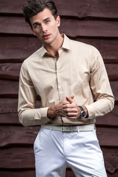 Retrato de joven hermoso hombre de moda contra la pared de madera — Foto de Stock