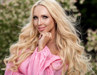 Açık havada portre sarışın bir genç güzel kadın lüks pembe elbise