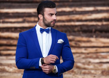 Genç güzel şık adam ağaç gövdeleri karşı olarak arka plan açık portresi