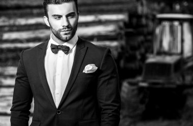 Genç güzel şık adam ağaç gövdeleri karşı olarak arka plan açık portresi