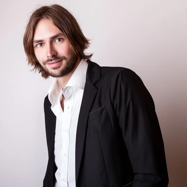 Elegant young long hair handsome man pose in studio — Stock Photo, Image