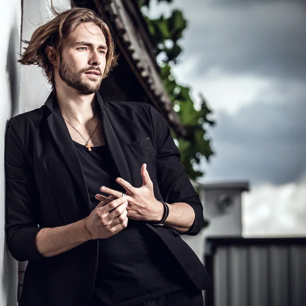 Elegante hombre guapo posa al aire libre —  Fotos de Stock