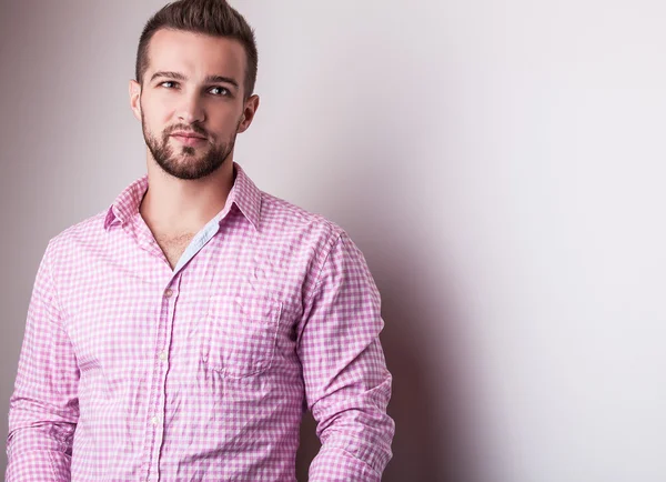 Jovem homem bonito em pose camisa colorida no estúdio — Fotografia de Stock