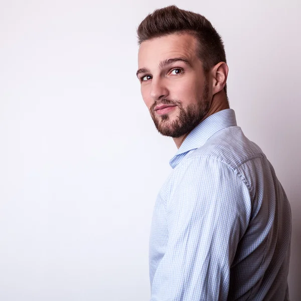 Jonge knappe man in kleurrijke shirt poseren in studio — Stockfoto