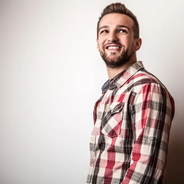 Jovem homem bonito em pose camisa colorida no estúdio — Fotografia de Stock