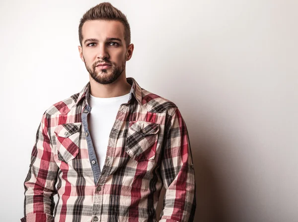 Jovem homem bonito em pose camisa colorida no estúdio — Fotografia de Stock