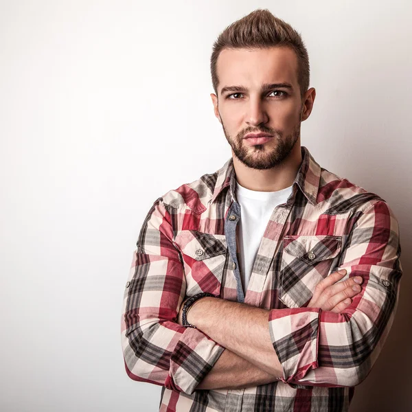 Jonge knappe man in kleurrijke shirt poseren in studio — Stockfoto