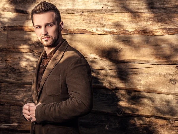 Retrato de joven hermoso hombre de moda contra la pared de madera — Foto de Stock