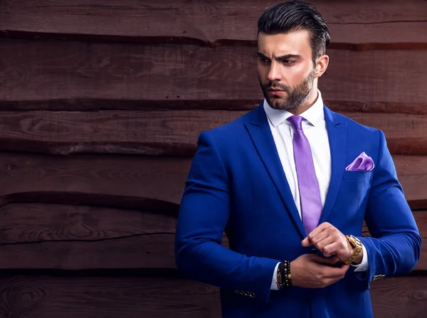 Retrato de jovem belo homem elegante contra a parede de madeira — Fotografia de Stock