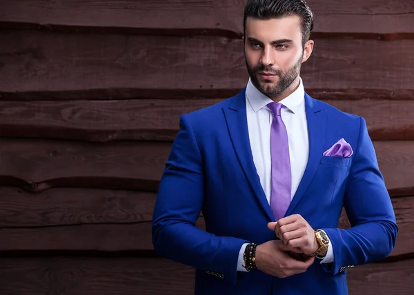 Ritratto di giovane bello uomo alla moda contro muro di legno — Foto Stock