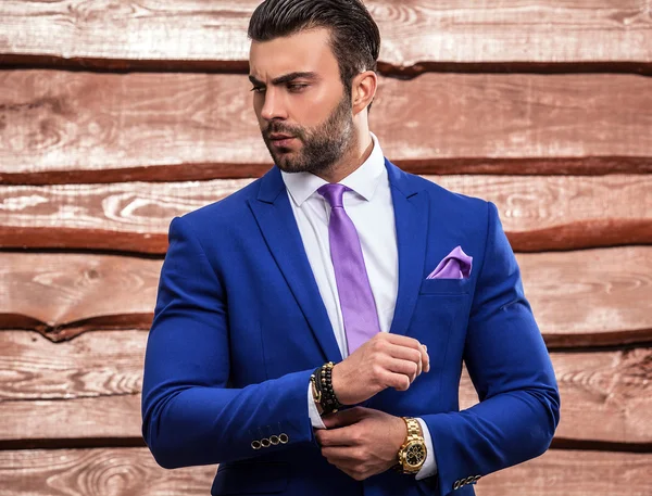 Ritratto di giovane bello uomo alla moda contro muro di legno — Foto Stock